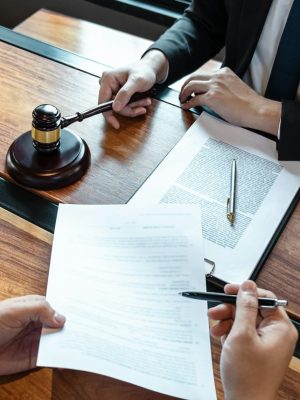 Male lawyer discussing negotiation legal case with client meeting with document contact in courtroom Male lawyer discussing negotiation legal case with client meeting with document contact in courtroom